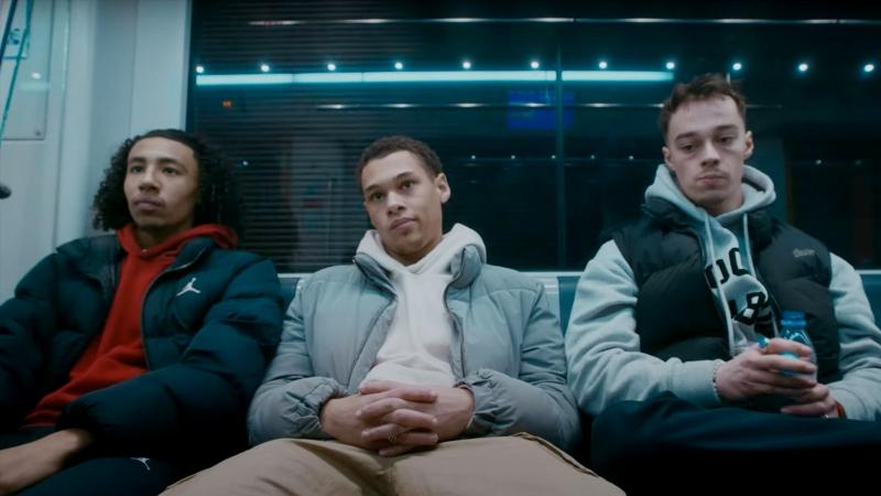 Drei Jungs sitzen in einer Bahn.