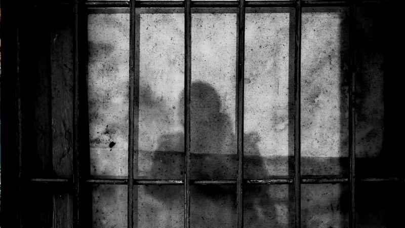 Gitterstäbe und ein Schatten auf der Wand
