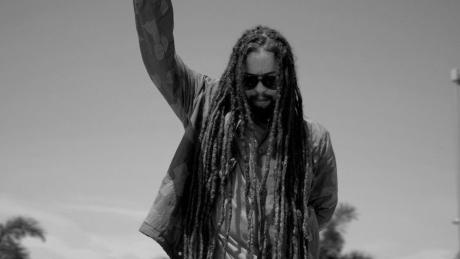 Jo Mersa Marley streckt einen Arm in die Luft in schwarzweiß