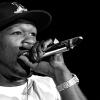 50 Cent rappt in ein Mikrofon in Schwarzweiß