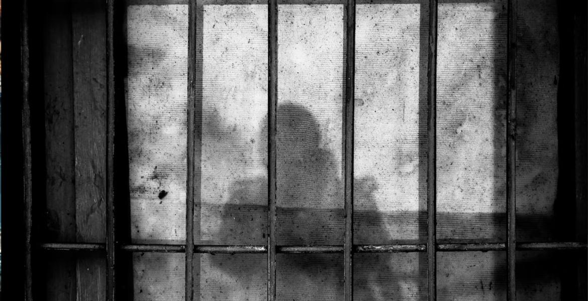 Gitterstäbe und ein Schatten auf der Wand