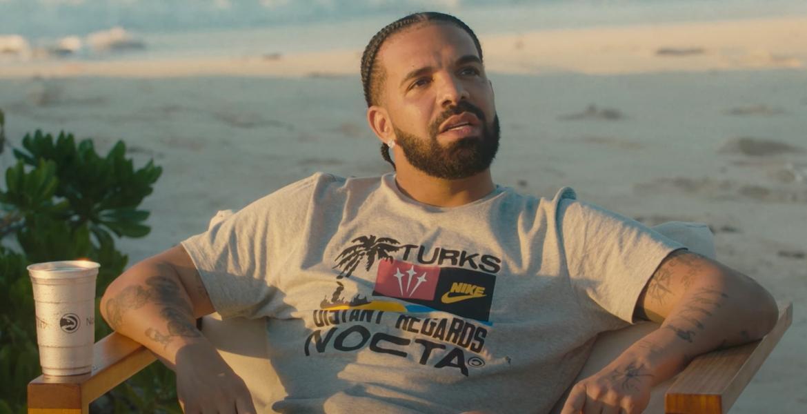 Drake sitzt am Strand